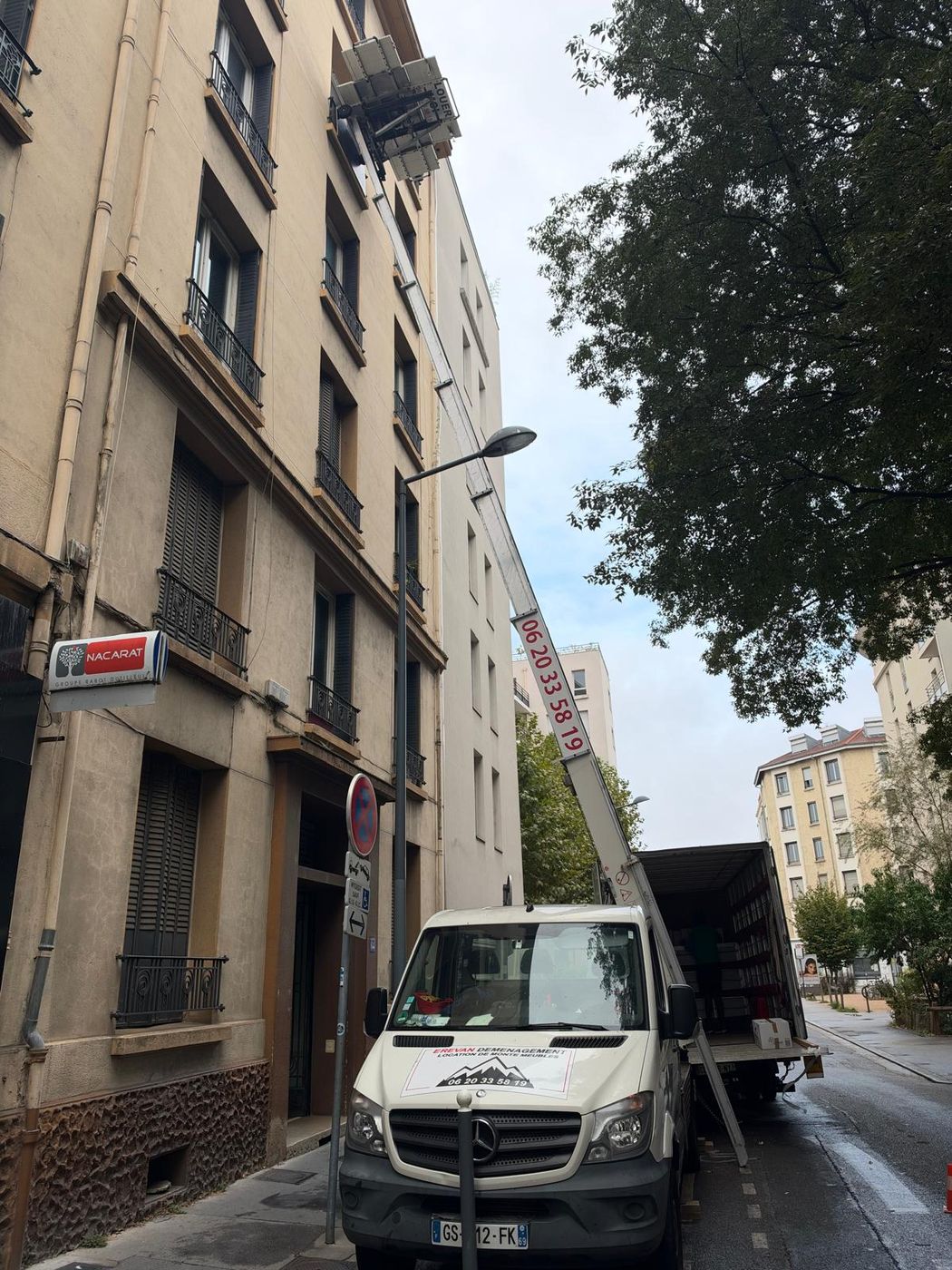 Monte-meubles et camion dans une rue étroite